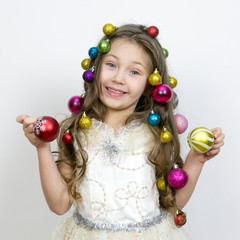 Girl with New Year's toys on a white background. A little girl with Christmas balls decorated her hair on her head.,