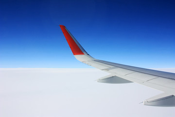 Fototapeta na wymiar Airplane wing in blue sky