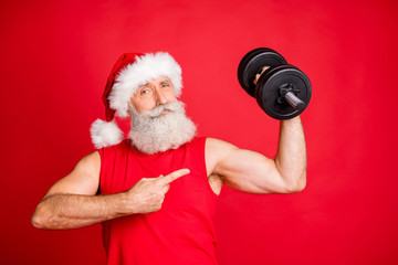 Portrait of cool santa claus sportsman in hat cap with white hairstyle holding dumbbells show...