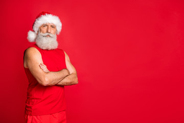 Turned photo of confident santa claus ready to workout wearing sports wear cap isolated over red background