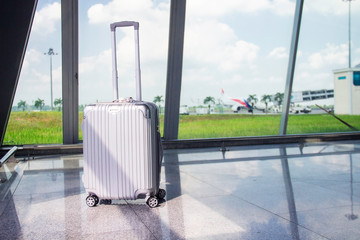 Travel suitcases/luggage/baggage in front of background of the plane on run way in the airport. Concept: transport and travel.