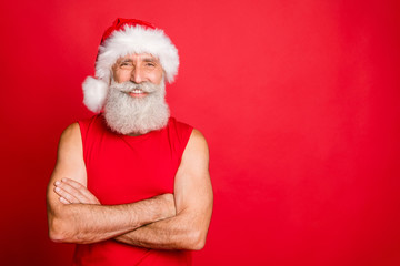 Portrait of charming trendy santa claus real coach with his hands crossed looking with toothy smile wearing nicholas cap hat sportswear isolated over red background