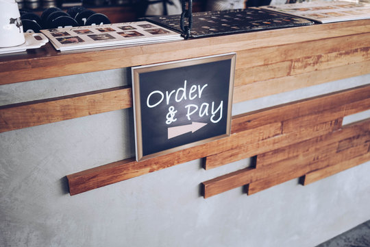 order and pay wooden chalkboard tag on counter bar in cafe or retail shop