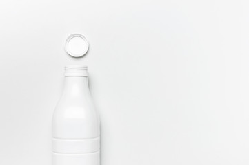 White plastic bottle containers for dairy products on light gray background top view flat lay. Plastic Kefir Yogurt Milk Bottle. Packaging template mockup. Layout for your design