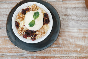 Apple crumble dessert with vanilla ice cream on the top on wooden table top view