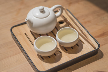 Chinese tea ceremony, asian traditional culture. White tea set on a wooden background.
