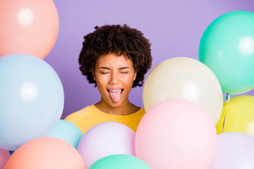 Fototapeta na wymiar Close-up portrait of her she nice attractive foolish cheerful cheery crazy playful hilarious wavy-haired girl showing tongue out among air balls isolated on violet purple lilac pastel color background