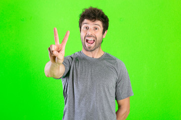Fototapeta premium caucasian crazy man making funny symbols over green background