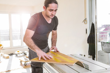 Handwerker schneidet parkett mit Kreissäge in einem neubau haus