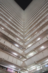 Bottoms up view of the cascading corridors opening up to a dark night sky at an old public housing estate in Ping Shek, Kwun Tong District, Kowloon, Hong Kong. Abstract architecture.