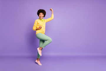 Fototapeta na wymiar Full length body size photo of cheerful cute charming fascinating girl rejoicing found her favorite song she could not find for long wearing green pants trousers yellow sweater isolated violet pastel