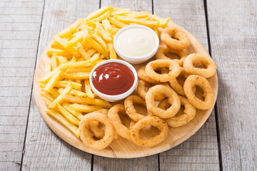French fries and onion rings with sauces