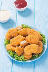 Chicken nuggets in plate on rustic background