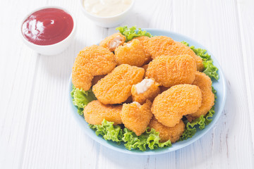 Chicken nuggets in plate on rustic background