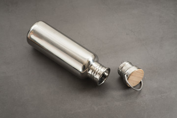 Durable, high quality reusable stainless steel bottle on gray background as alternative to plastic bottles. Toxin, BPA, plastic free zero waste option for drinking tap water at home or at the office.