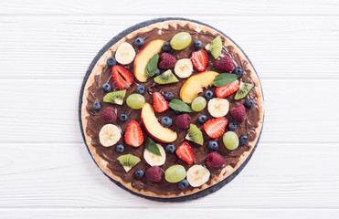 Fruit pizza with nut nougat cream , fruit and berries