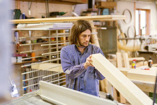 Carpenter holding timber in workshop