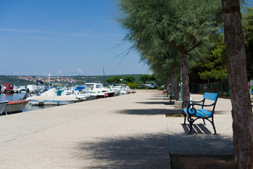 Blue bench on the waterfront with boats