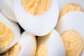 Macro shot of some halved hard boiled eggs in a bowl.