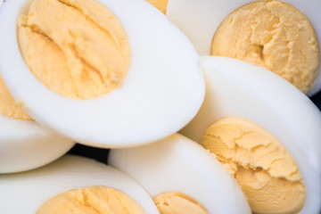 Macro shot of some halved hard boiled eggs in a bowl.