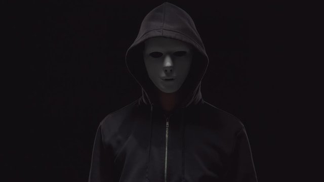Portrait of computer hacker in hoodie. Obscured dark face. Data thief, internet fraud, darknet and cyber security .