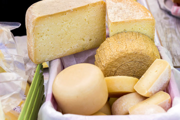 hard cheeses sliced on a wooden board on a dark rustic background