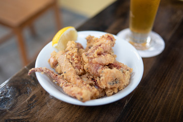 Deep fried calamari with a slice of lemon and a pint of beer.