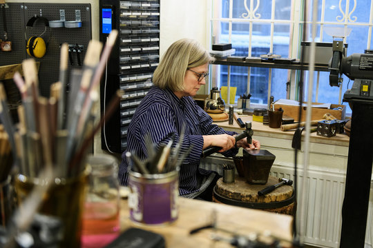 Goldsmith working at anvil