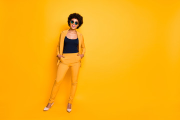 Fototapeta premium Full size photo of positive cheerful elegant afro american girl have fun rest relax feel dream dreamy wear stylish fashionable outfit isolated over yellow color background