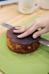 Making a layer cake. Cutting the top off of cakes with a serrated knife to level cake.