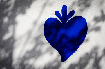 Il tipico cuore strombolano dipinto con la vernice blu su un muro