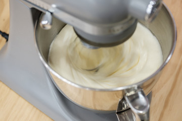 Mixing eggs, flour and sugar in bowl with motor mixer. Preparing ingredients for baking a cake.