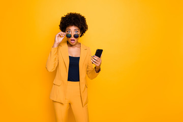 Portrait of shocked afro american girl use smartphone read news on social network account get...