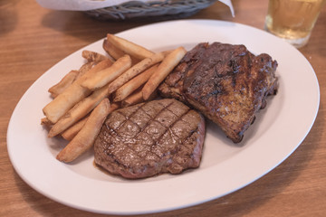 Rib eye Steak and Ribs with Potato Fries.