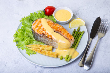 Grilled salmon with asparagus, corn mini and hollandaise sauce. Close-up.