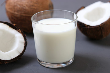 Milk and broken coconuts on the table. Vegetable milk, a veggie drink.