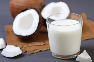 Fototapeta na wymiar Milk and broken coconuts on the table. Vegetable milk, a veggie drink.