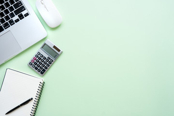 Flat lay,Top view office table desk. Workspace with calculator, pen ,laptop , note on the pastel green background.Copy Space for text,Empty Blank to word.Business Finance,Education Technology Concept.