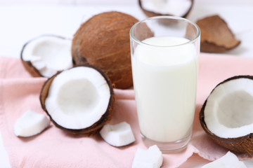 Milk and broken coconuts on the table. Vegetable milk, a veggie drink.