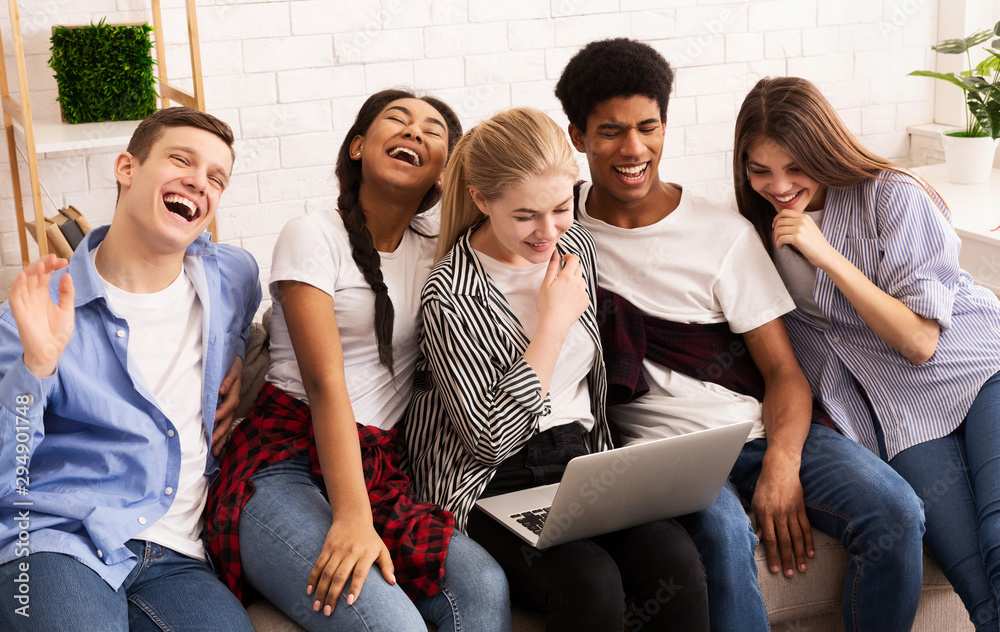 Wall mural Laughing teenagers watching funny content on laptop