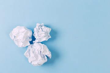 Fototapeta premium Crumpled paper balls, waste and recycling concept on blue background