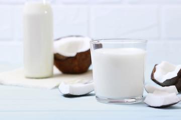 Milk and broken coconuts on the table. Vegetable milk, a veggie drink.
