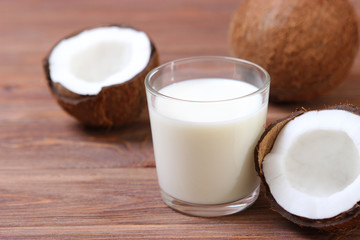 Milk and broken coconuts on the table. Vegetable milk, a veggie drink.