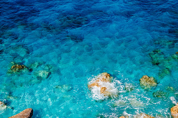 Naklejka na ściany i meble Background turquoise water sea with stones beach, transparent bottom