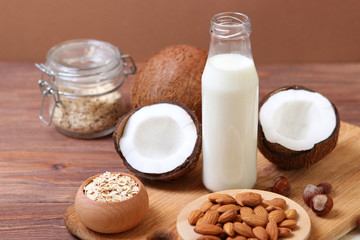 Obraz na płótnie Canvas Different types of vegetable milk on the table. Coconut, oatmeal, hazelnut, almond milk. Vegetarian milk.