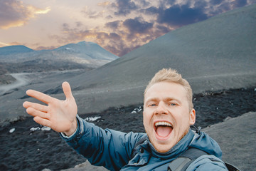 Tourist takes selfie on top of volcano Mount Etna, Sicily Italy. Mountain travel concept