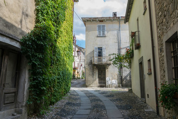 Fototapeta na wymiar Alley with walls covered in green ivy in a small traditional town in Italy