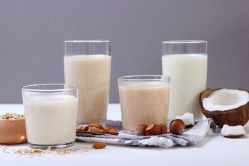 Different types of vegetable milk on the table. Coconut, oatmeal, hazelnut, almond milk. Vegetarian milk.