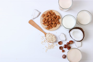 Fototapeta na wymiar Different types of vegetable milk on the table. Coconut, oatmeal, hazelnut, almond milk. Vegetarian milk.