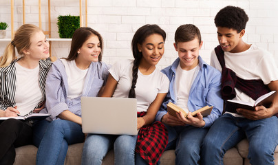 Happy students preparing for exams together on sofa
